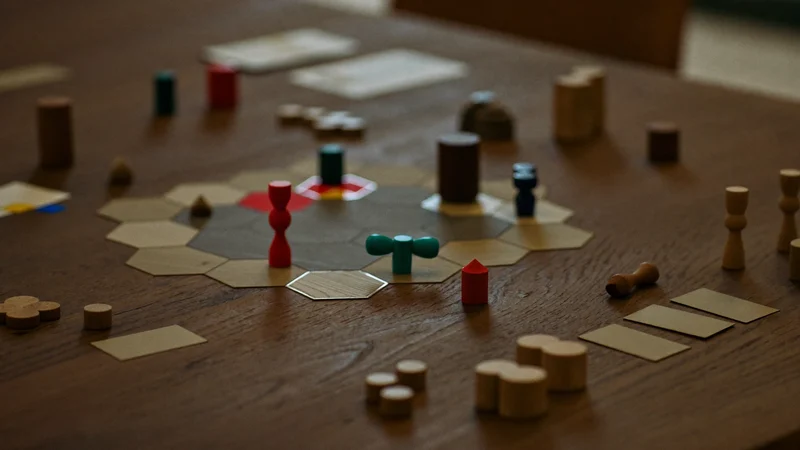 Gioco di strategia a partita in corso su tavolo di rovere con tessere e segnalini